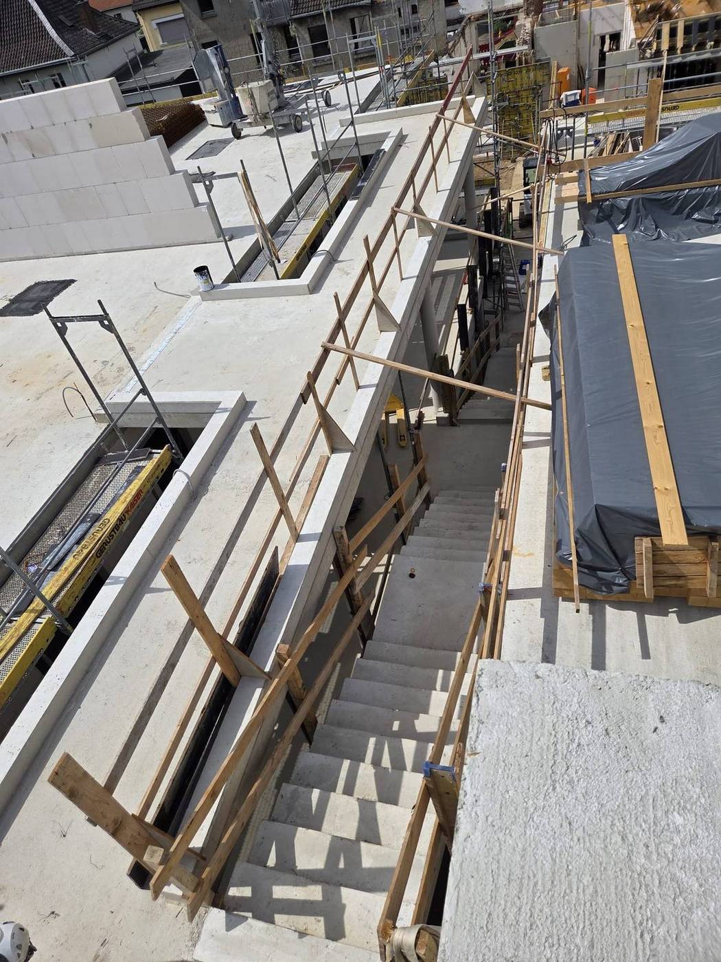 Fertig betonierte Treppe im Rohbau mit Absturzsicherung aus Holz