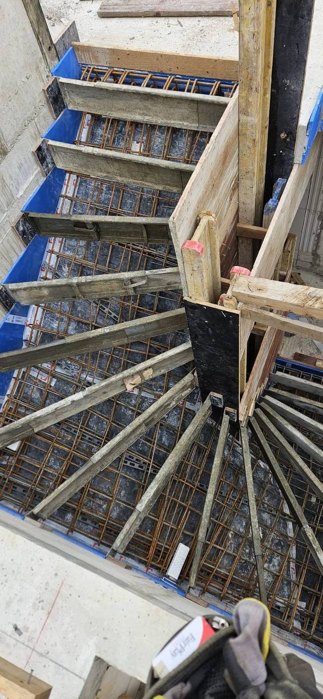 Blick von oben in die Schalung einer gewendelten Treppe mit Bewehrung