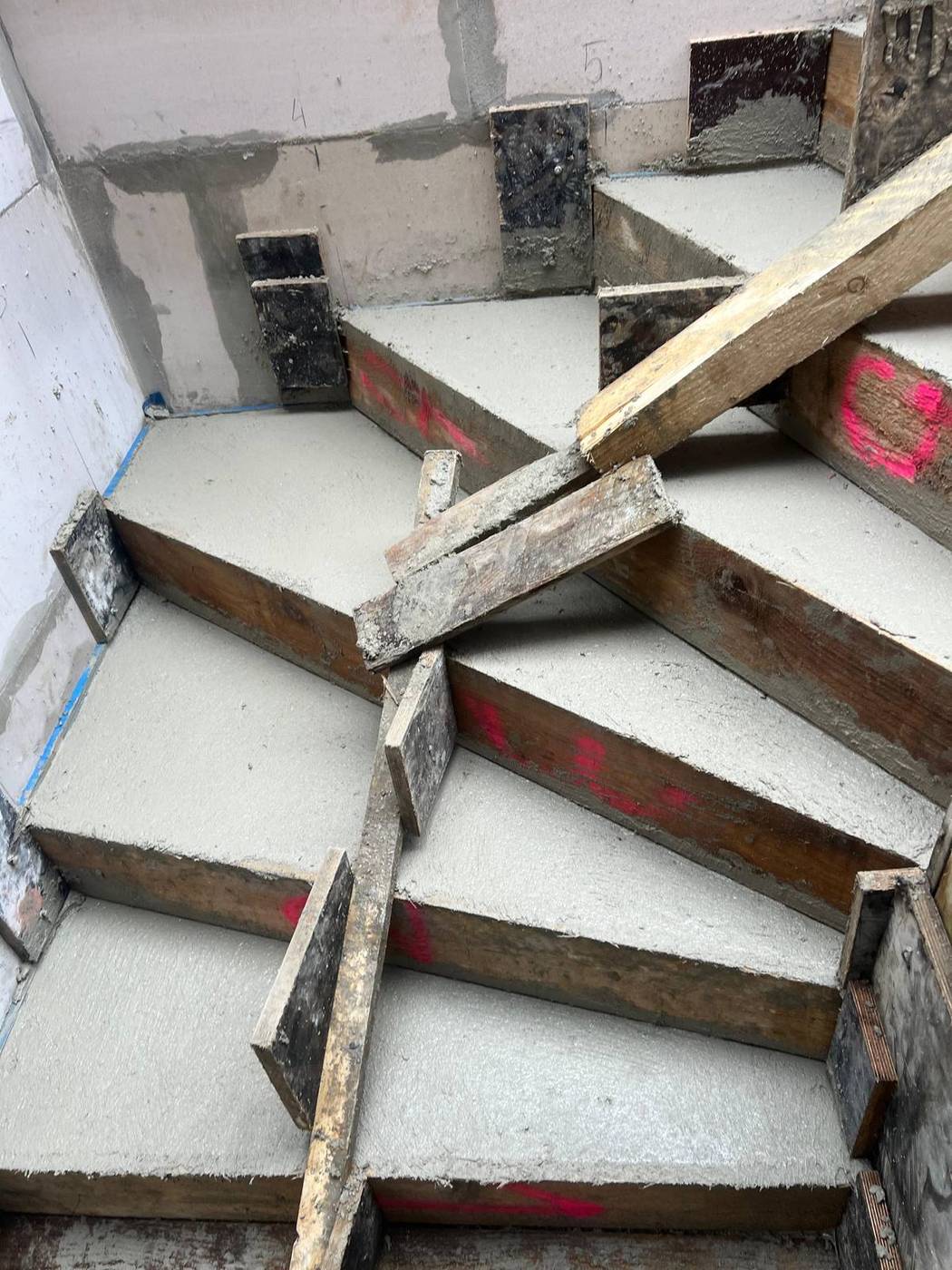 Treppenschalung im Rohbau mit Holzstützen vor einer Dämmwand