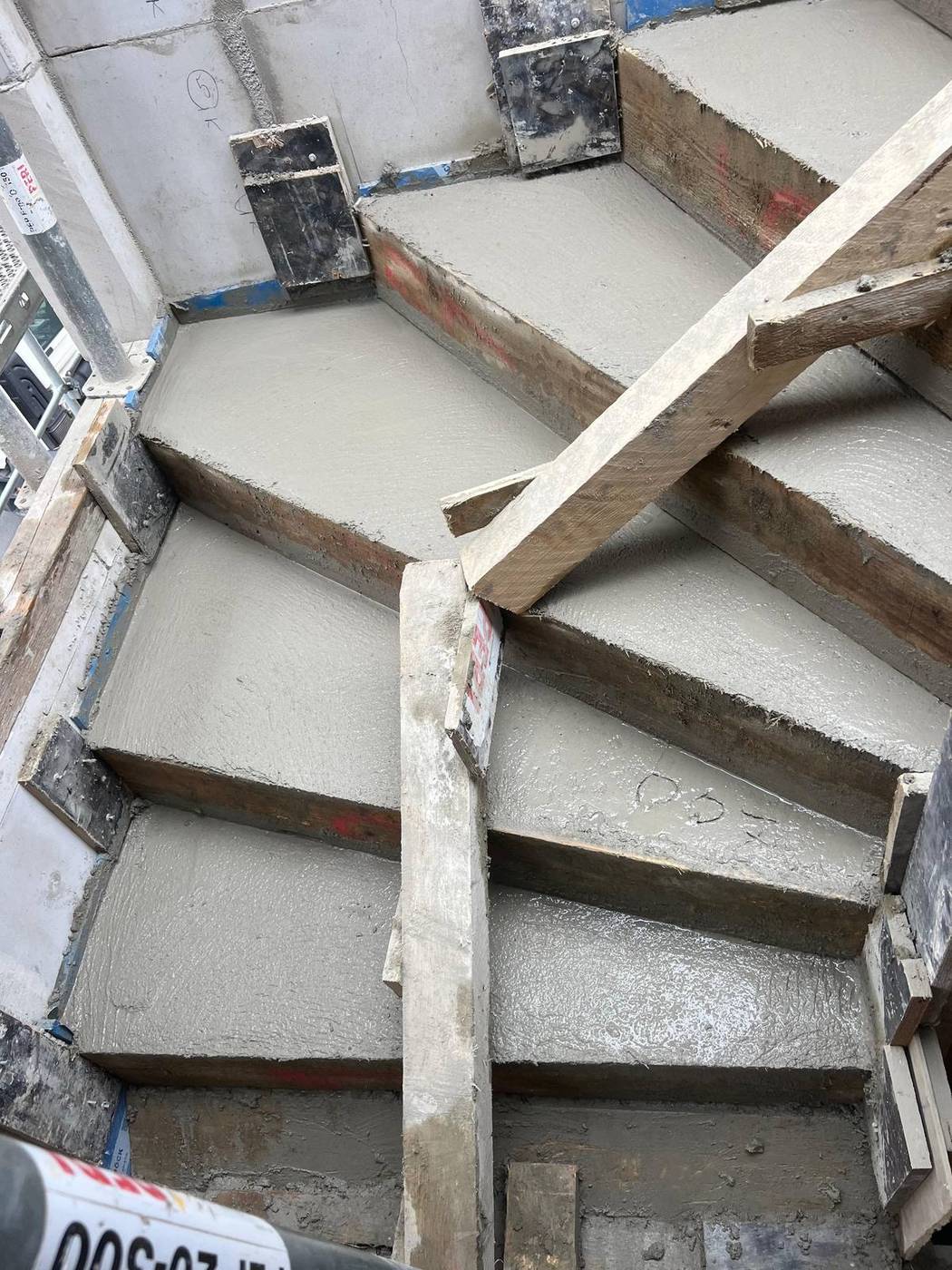 Betonierte Treppe mit Schalung und markierten Stufen