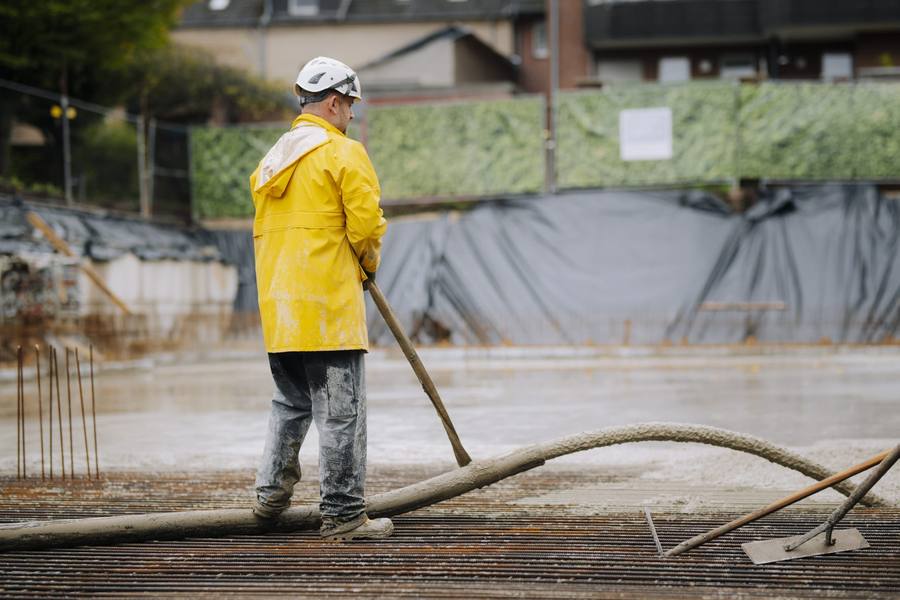 Bauarbeiter mit Betonschlauch auf der Baustelle